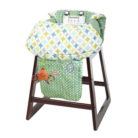 The Nuby 2-in-1 Universal Size Shopping Cart & High Chair Cover features a green, blue, and white geometric pattern, fits most seats, and includes a small hanging plush toy for baby entertainment.