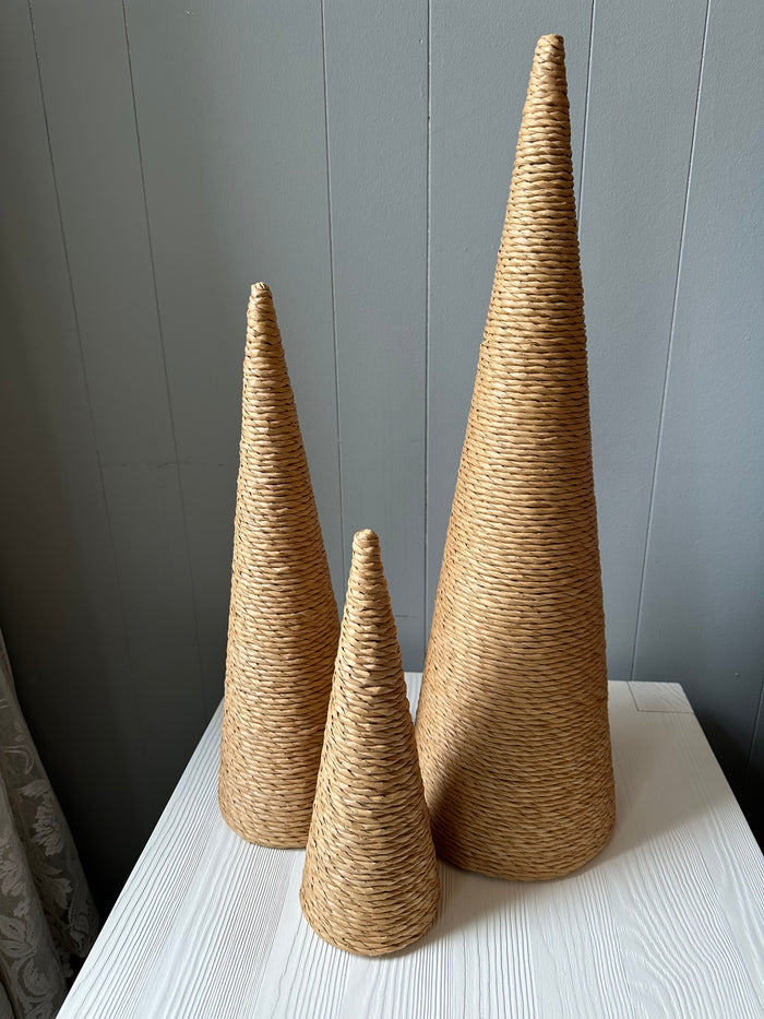 Three cones of differing heights resembling trees wrapped in brown twine.