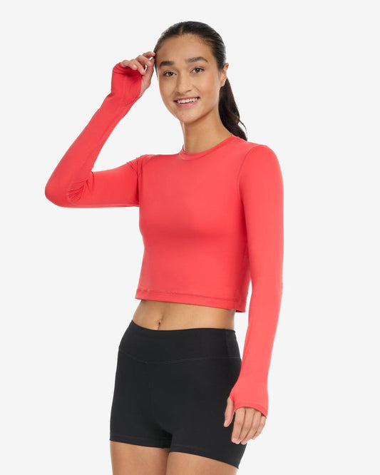 A woman wearing a red extended body length crop top on a white background