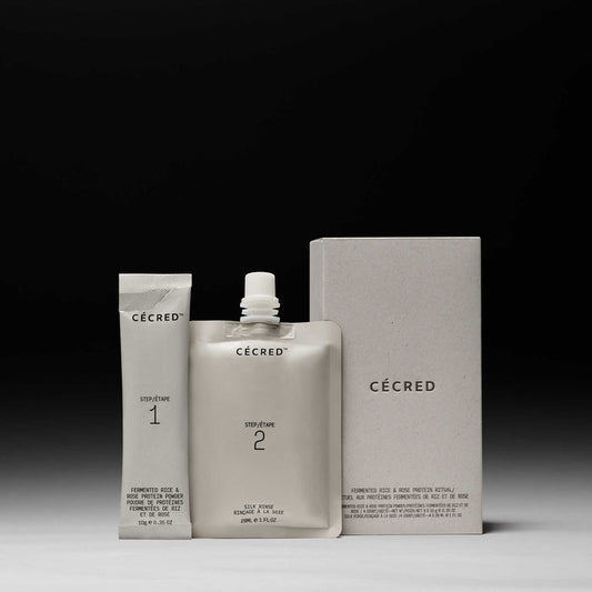 Cécred Fermented Rice & Rose Protein Ritual 2-step kit showing Step 1 powder tube, Step 2 silk rinse pouch, and product box displayed against a gradient grey background