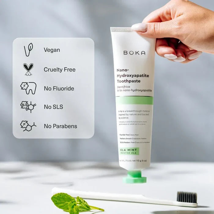 Boka toothpaste tube held by a hand with product features displayed on a card.