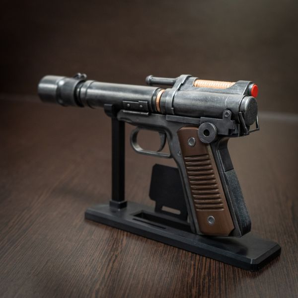 Star Wars Outlaws gaming setup background display: Kay Vess blaster replica