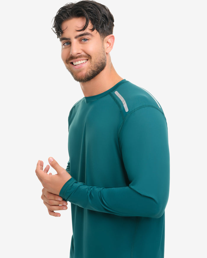 Man wearing a teal athletic shirt on a white background