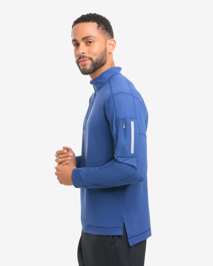 Man wearing a blue athletic jacket and black shorts on a white background