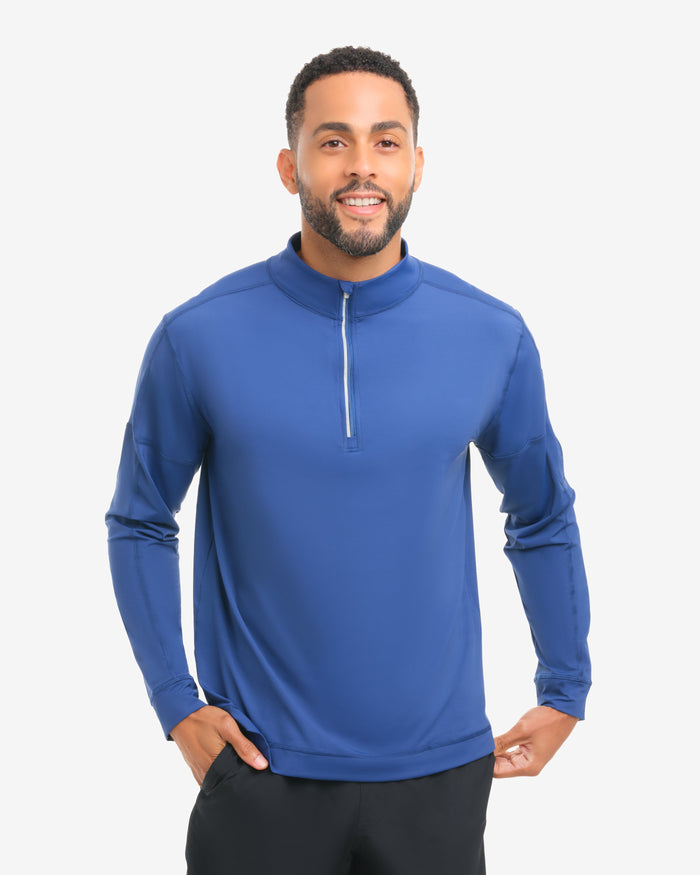 Man wearing a blue long-sleeve athletic shirt and black shorts on a white background