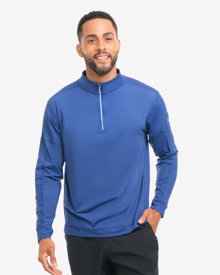 Man wearing a blue long-sleeve athletic shirt with a white zipper on a white background