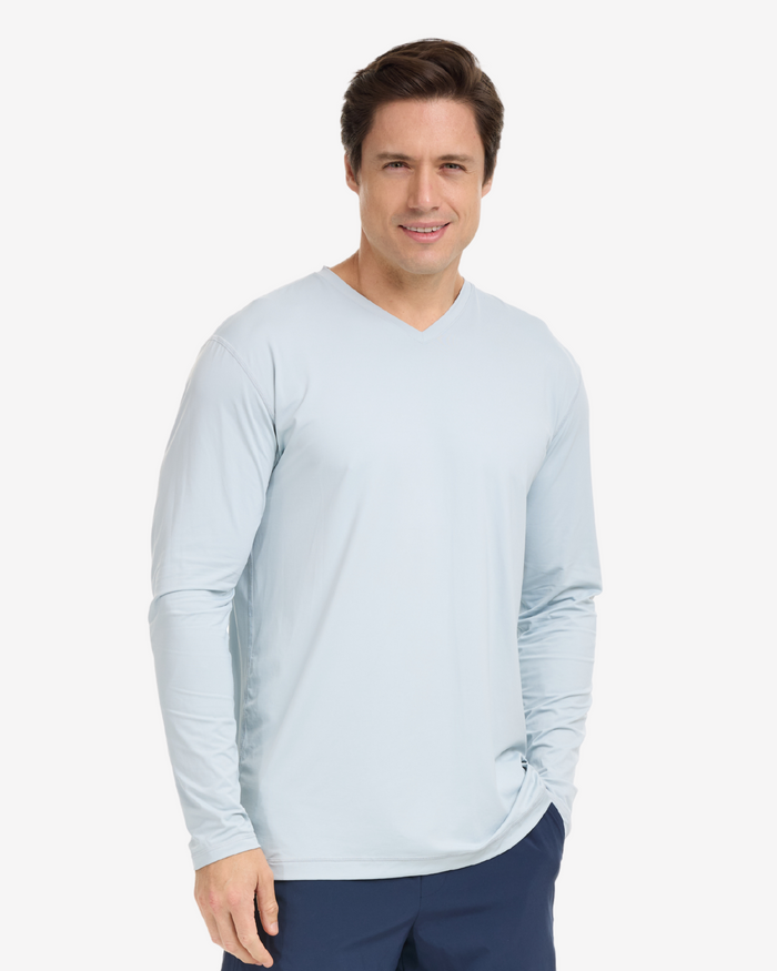 A man wearing a gray long-sleeved V-neck shirt, on a white background.