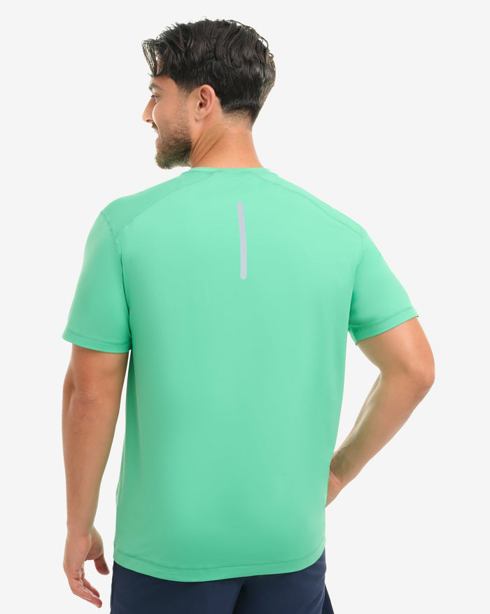 Man wearing a jade athletic shirt and navy shorts on a white background