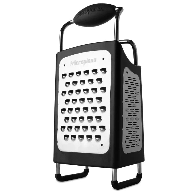 Box grater with black handle and body on a white background, featuring the Microplane brand.