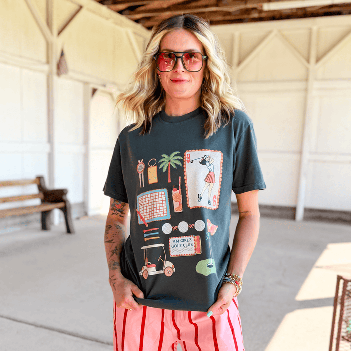 Woman wearing a graphic t-shirt with colorful designs in an indoor setting.