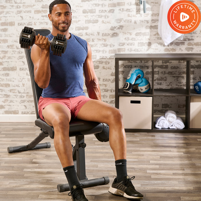 Man seated on a bench doing a bicep curl with one PowerUp Plus adjustable dumbbell.