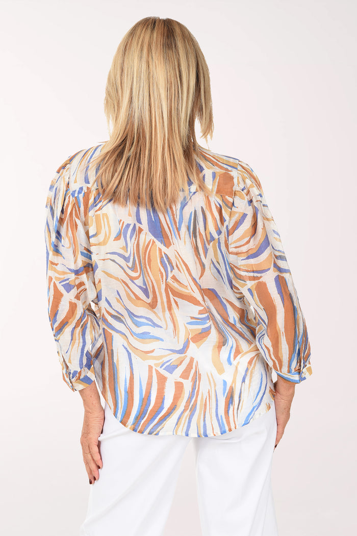 Woman wearing a patterned blouse with a white background