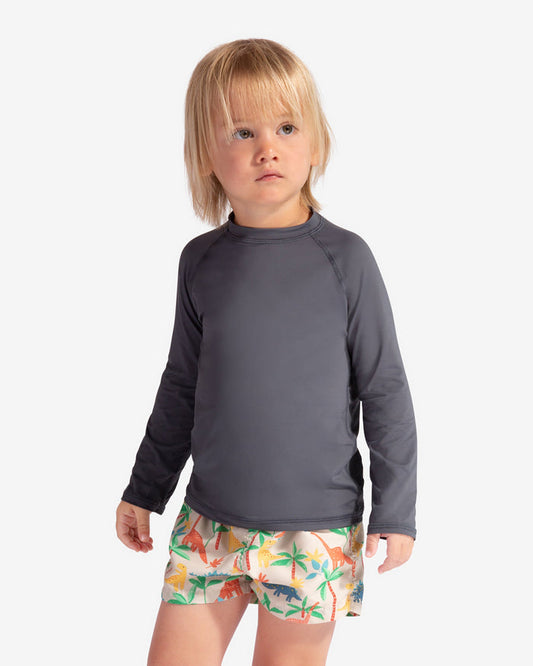 Child wearing a gray long-sleeve shirt and colorful shorts on a white background