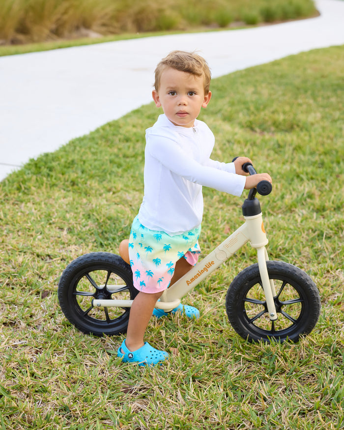 Child riding a balance bike on grass