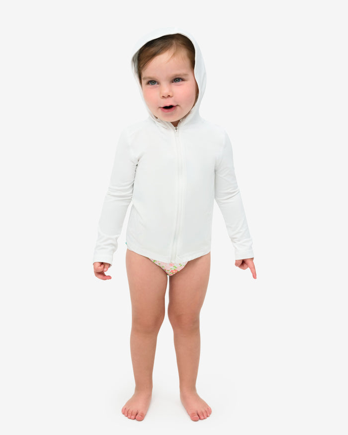 A toddler wearing a long sleeve full zip hoodie top in white on a white background