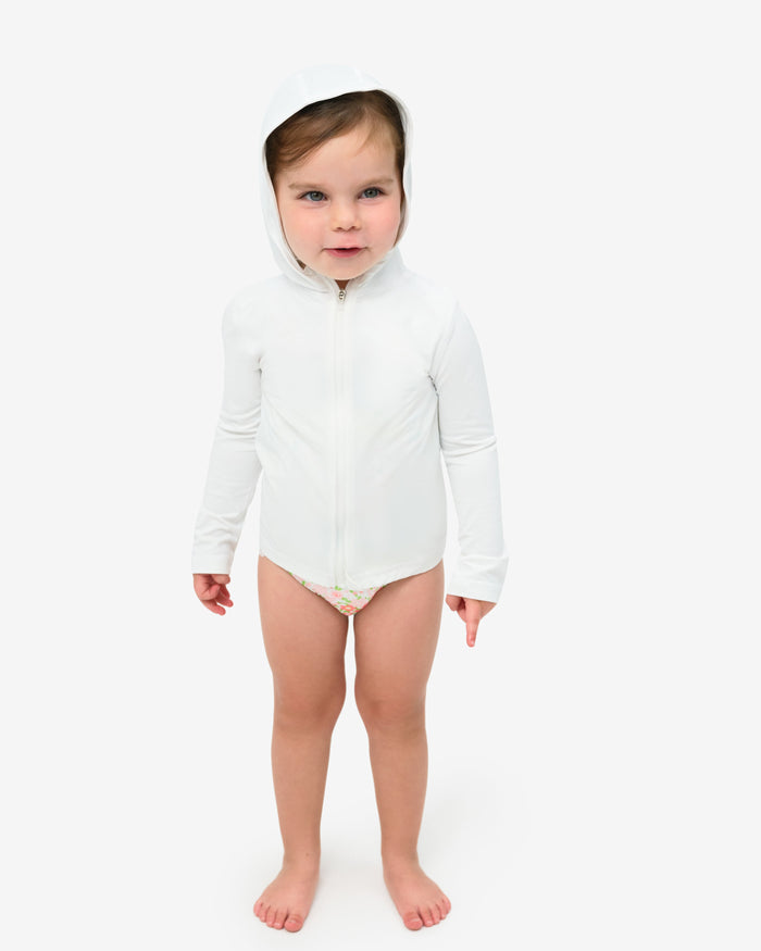 A toddler wearing a long sleeve full zip hoodie top in white on a white background