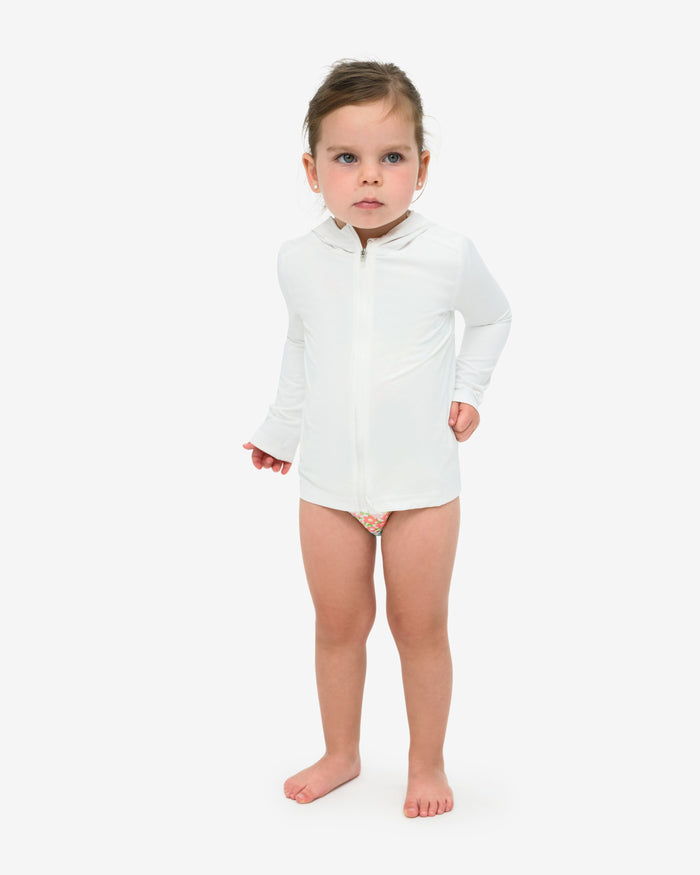 A toddler wearing a long sleeve full zip hoodie top in white on a white background