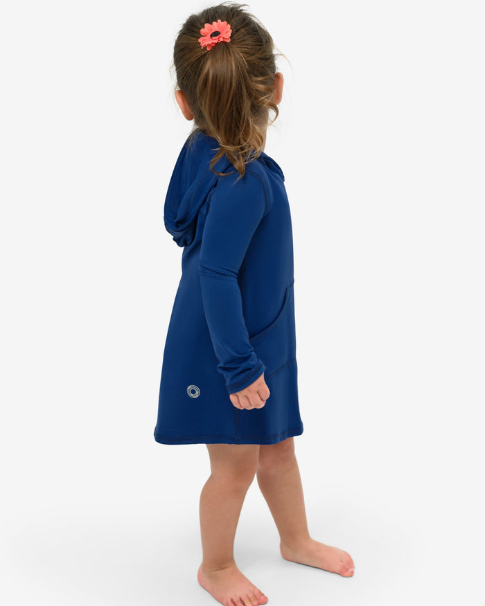 A toddler in a blue hoodie dress with long sleeves and a hood, standing against a white background.