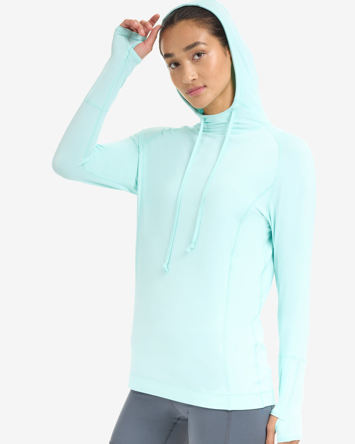 A woman wearing a unisex hoodie in mint color.