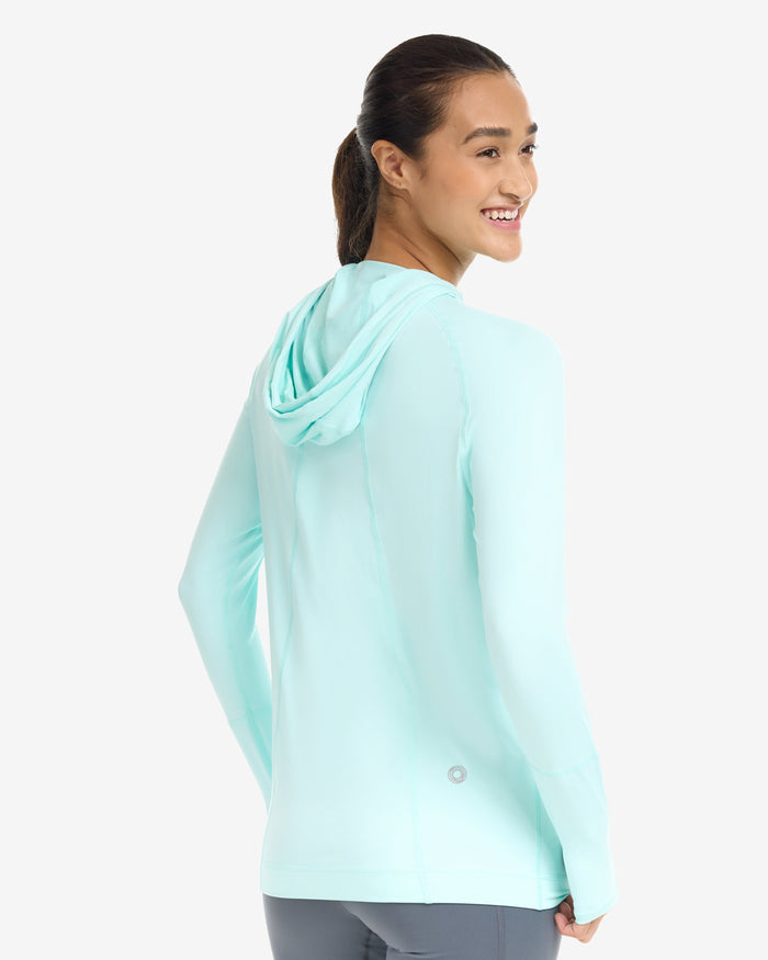 A woman wearing a unisex hoodie in mint color.