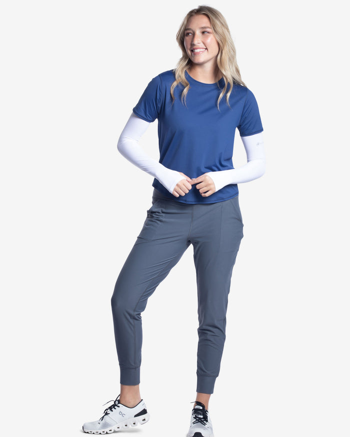 Person wearing grey jogger pants and white athletic shoes on a white background
