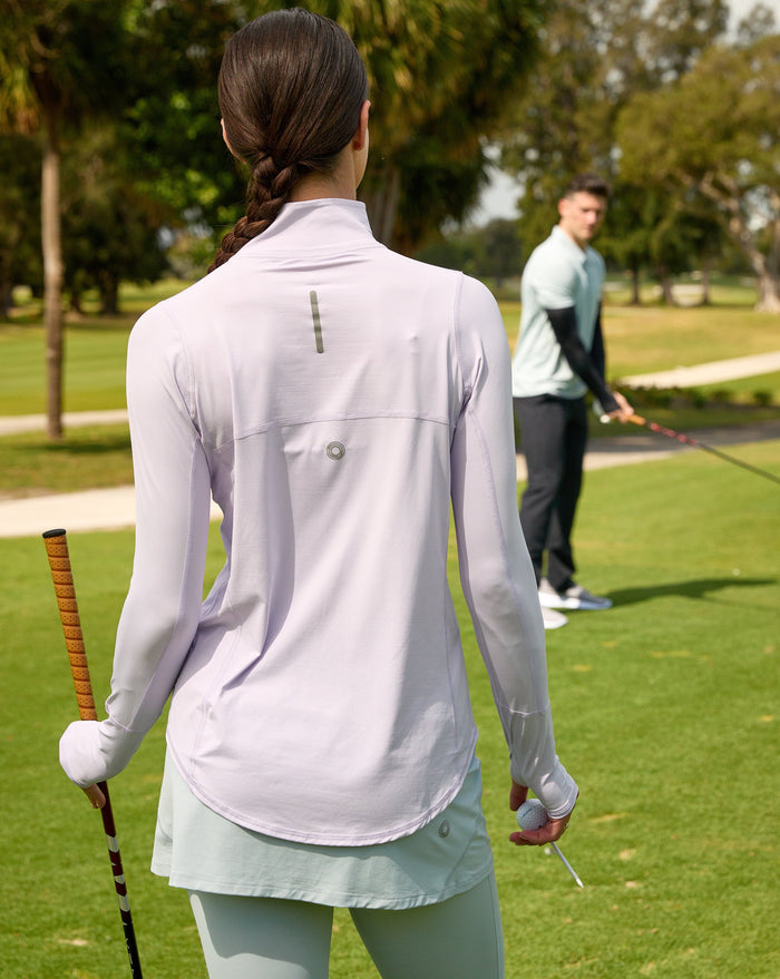 Women playing golf wearing lavender relaxed mock zip top with soft grey skort. (Style 3002) - BloqUV