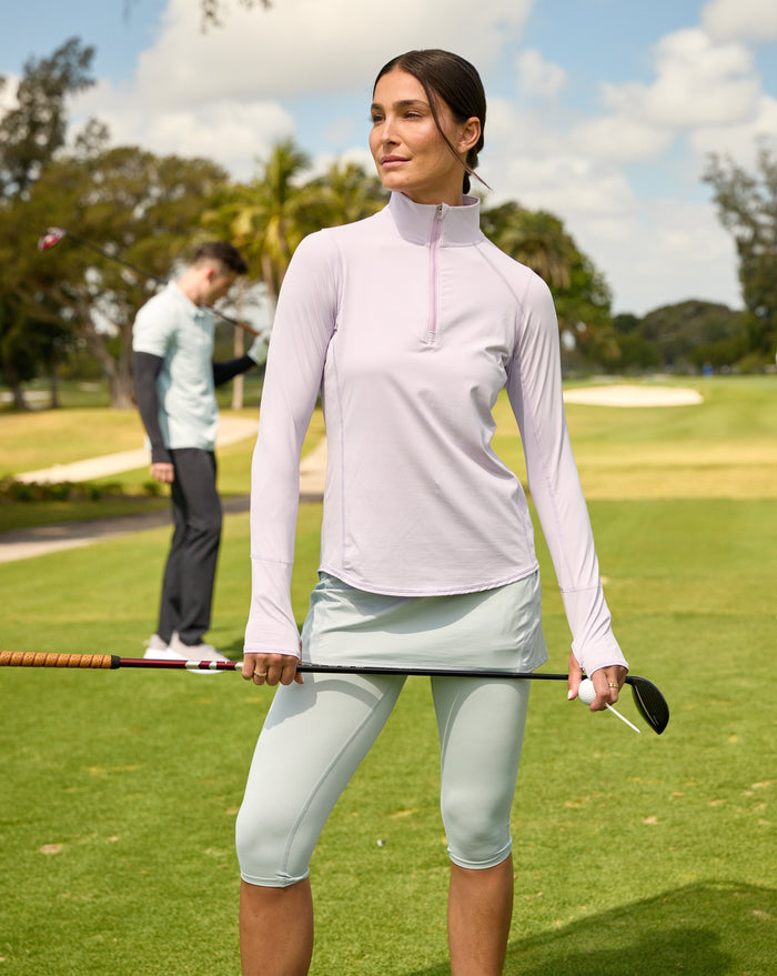 Women playing golf wearing lavender relaxed mock zip top with soft grey skort. (Style 3002) - BloqUV