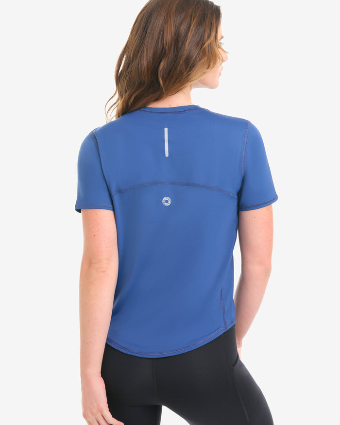 Woman wearing a blue athletic shirt with a white logo on a white background