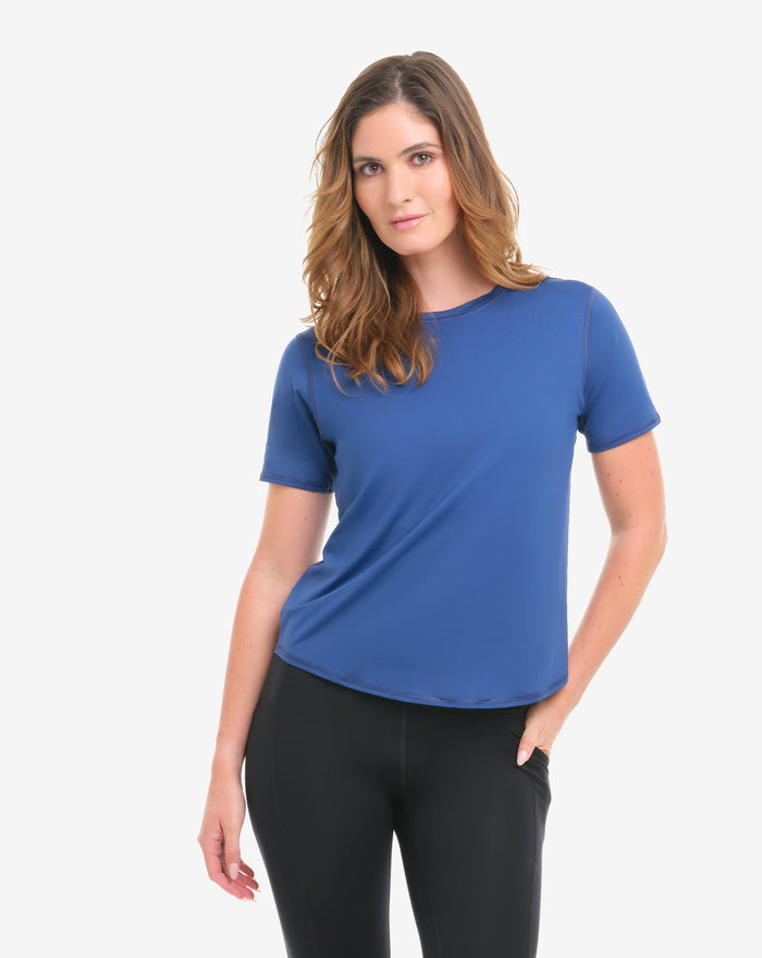 Woman wearing a blue t-shirt and black leggings on a white background