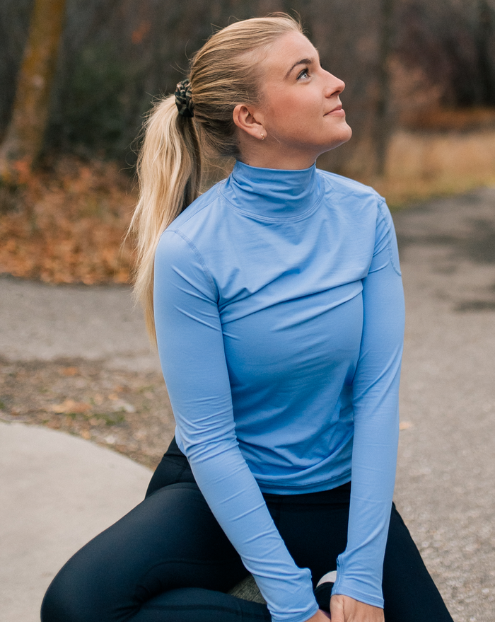 Women sitting outside wearing indigo turtle neck top with black tights. (Style 2013) - BloqUV